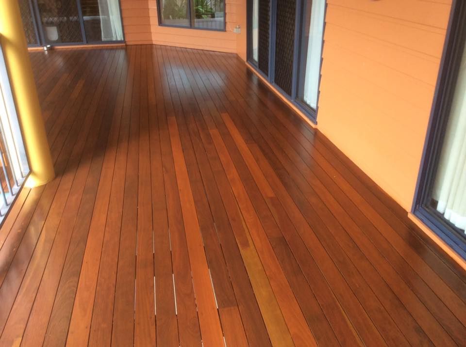 A Wooden Deck with A Yellow Wall in The Background — Finish It Floor Sanding in Bucca, QLD