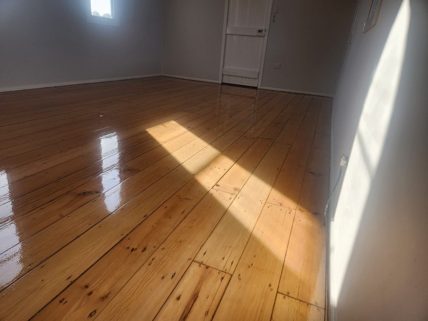 A Room with A Wooden Floor and A Window — Finish It Floor Sanding in Gladstone, QLD