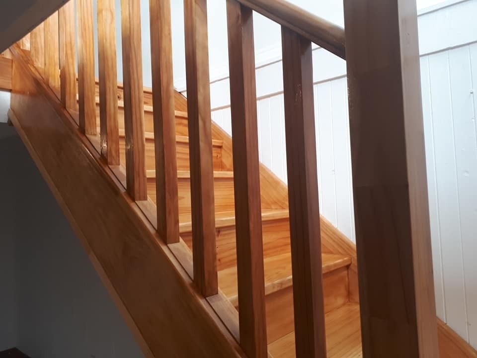 A Close up Of a Wooden Staircase with A Railing — Finish It Floor Sanding in Gladstone, QLD