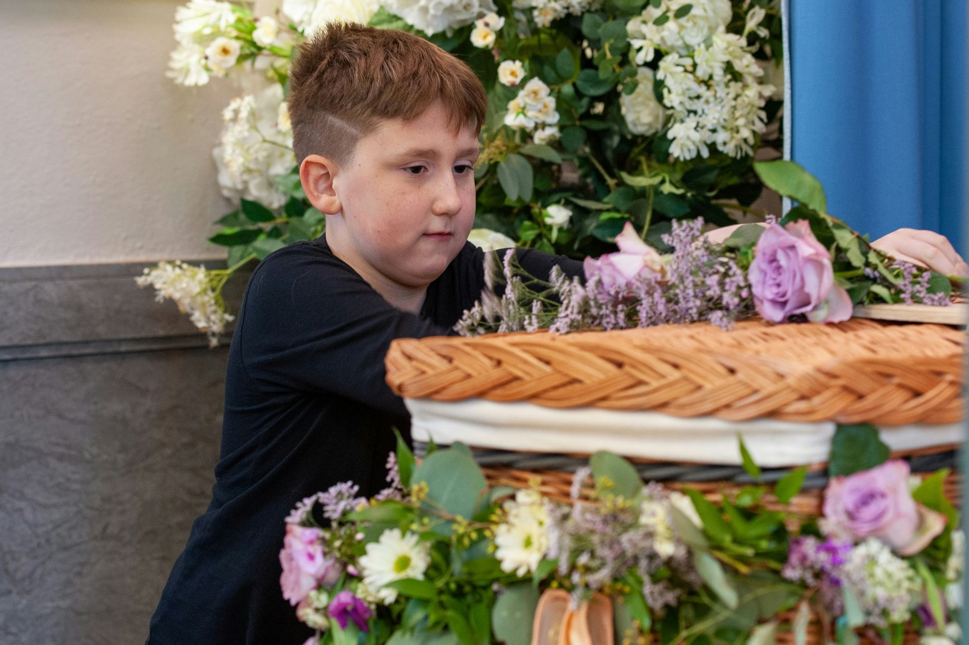Kind bij graf met bloemen – zacht symbool van rouwverwerking en afscheid nemen