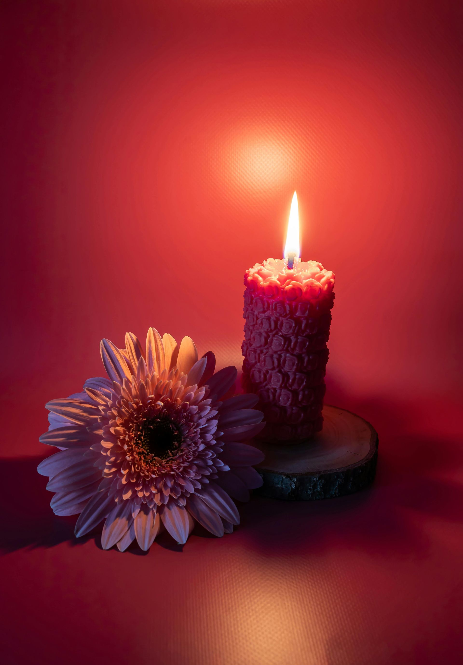 Sereen brandende kaars met witte lelies als symbool van herinnering en troost