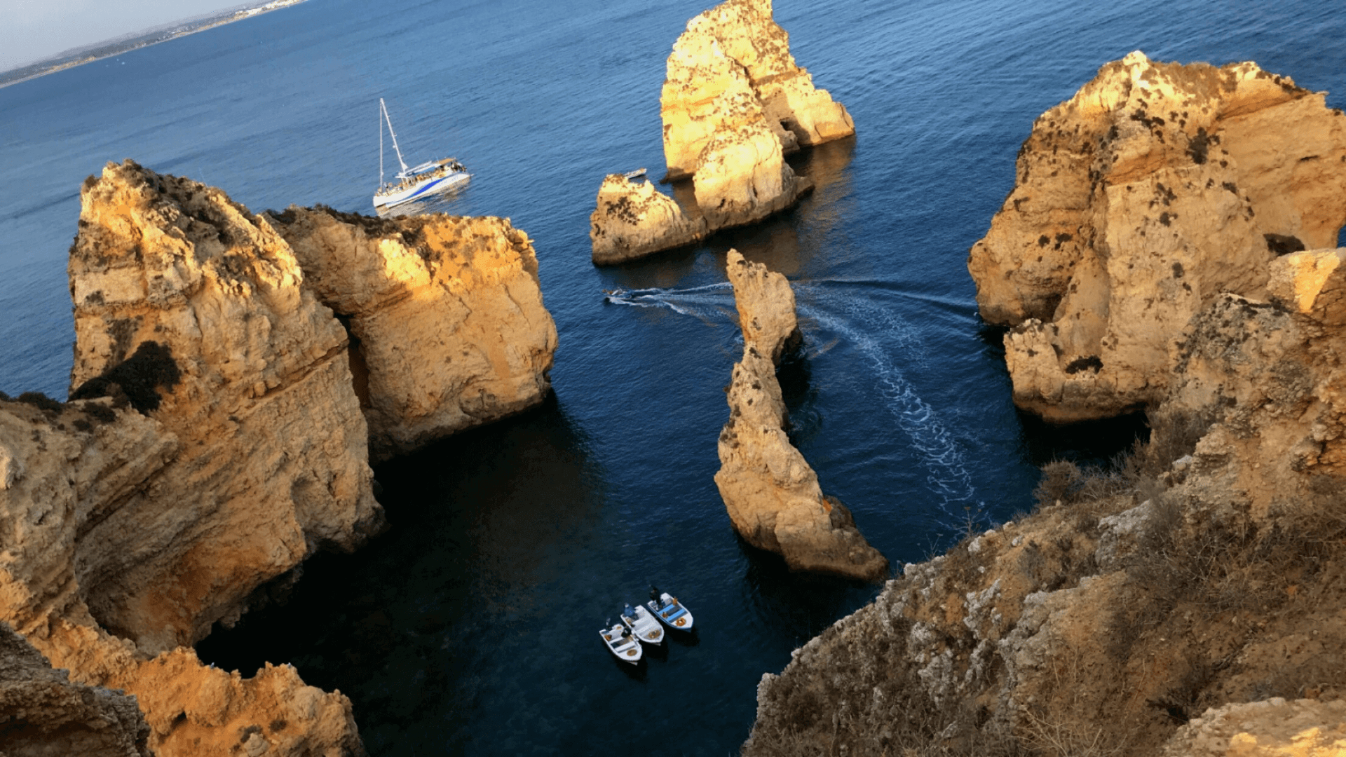 portugal algarve coast cliffs with water and speed boats