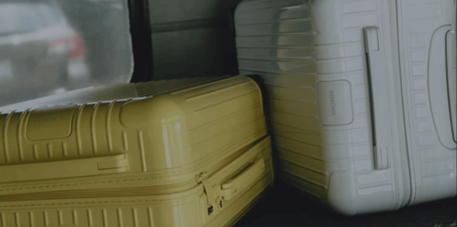 rimowa yellow and white suitcases laying on side