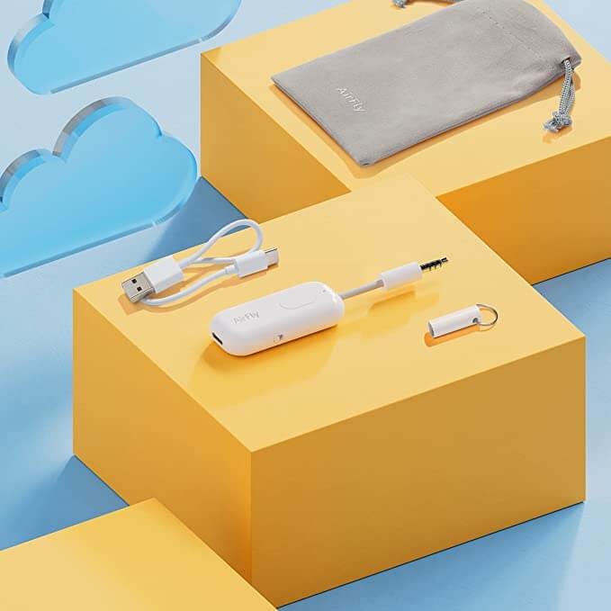 airfly pro white wireless transmitter for bluetooth on yellow box and blue cloud background grey carrying case