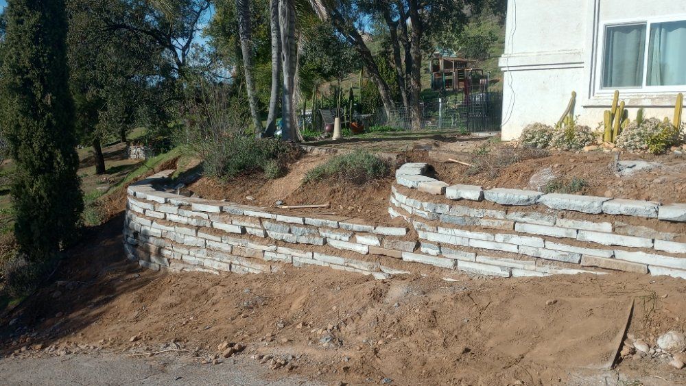 A brick wall is being built in front of a house.
