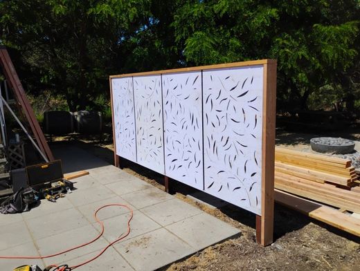A wooden fence is being built in a backyard