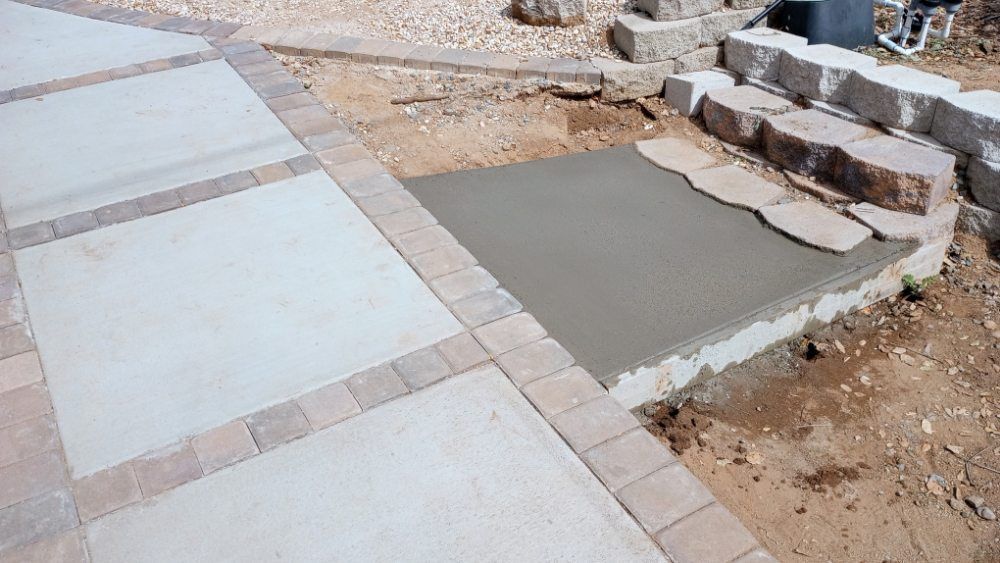 A concrete walkway is being built next to a rock wall.
