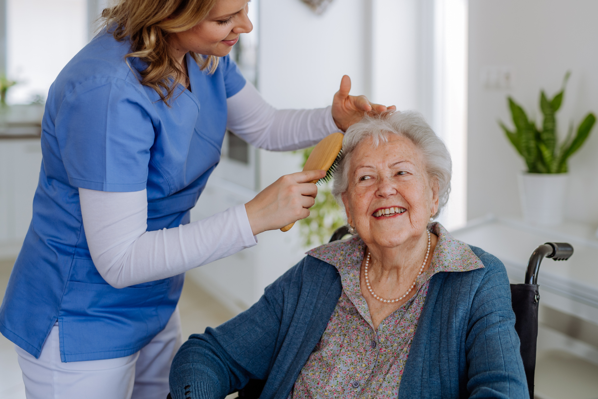 Care home: Elderly people at a table with a nurse, one woman in a wheelchair, a doctor talking to others.
