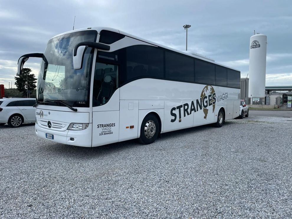Un autobus bianco con la scritta "STRANGERS"