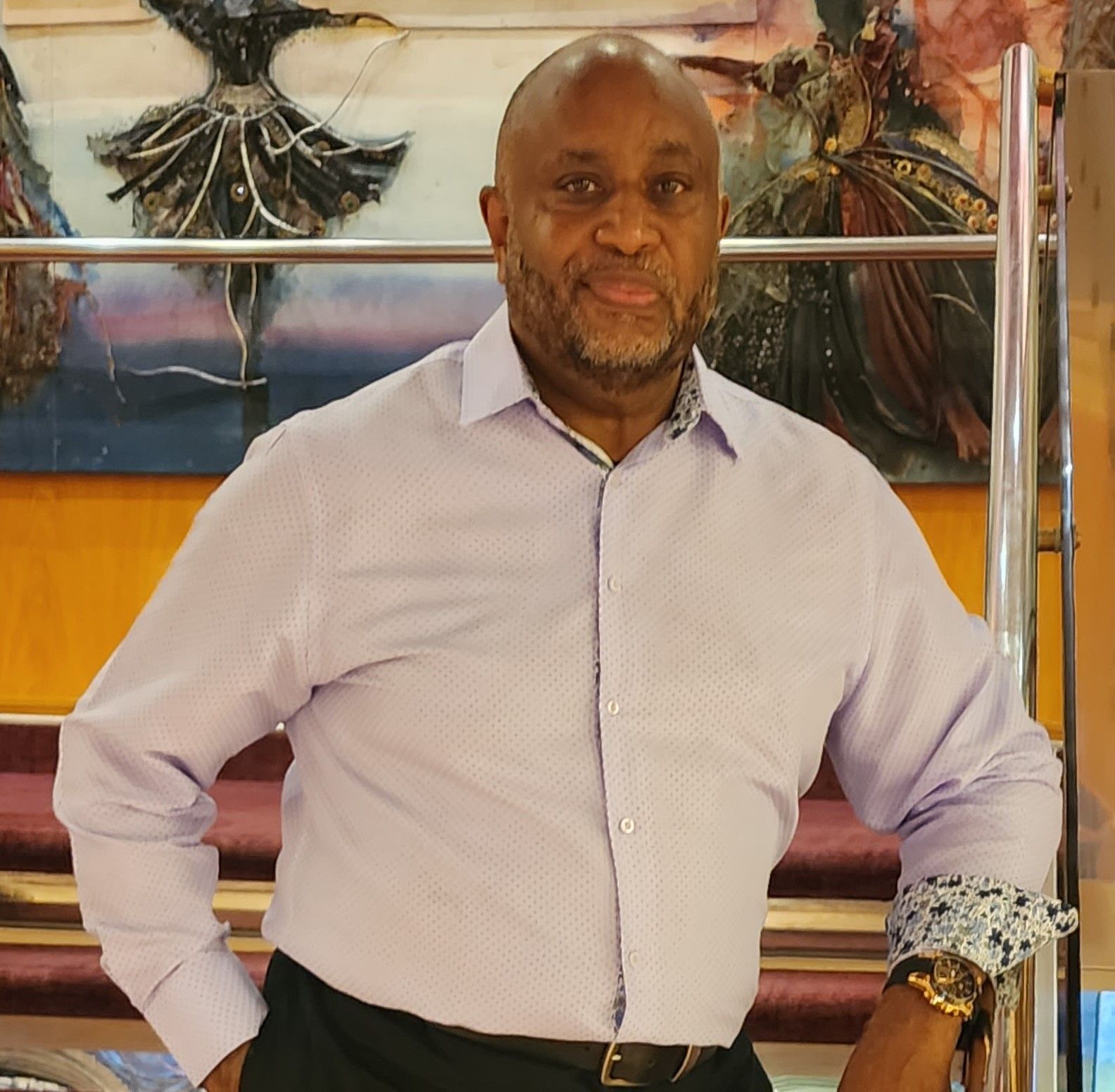 Agency owner Ronald Rivers wears a light purple shirt.