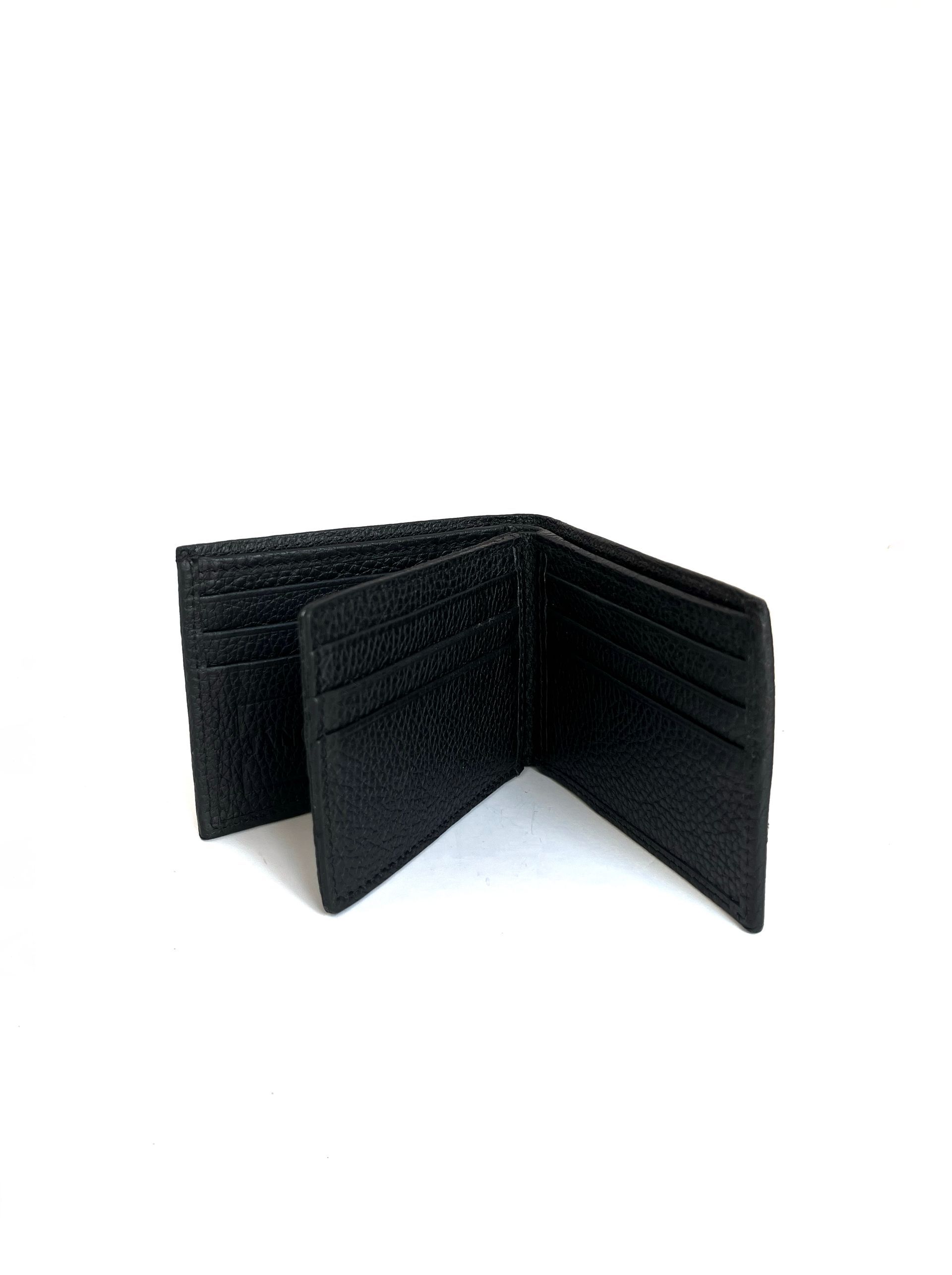 Cartera de piel de color negro, abierta, con ranuras para tarjetas.