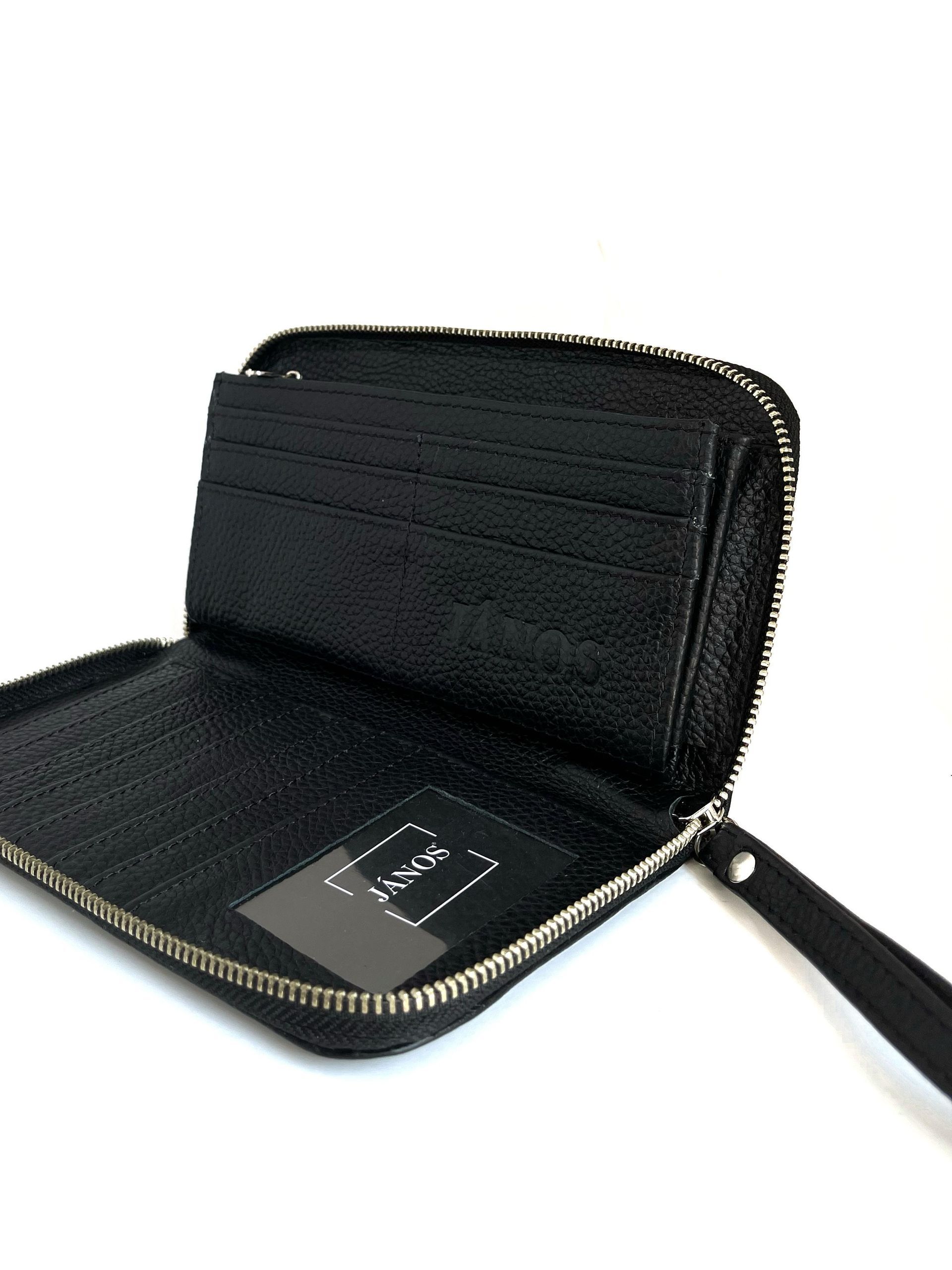 Cartera negra con cremallera, abierta, que deja ver ranuras para tarjetas y correa para la muñeca.