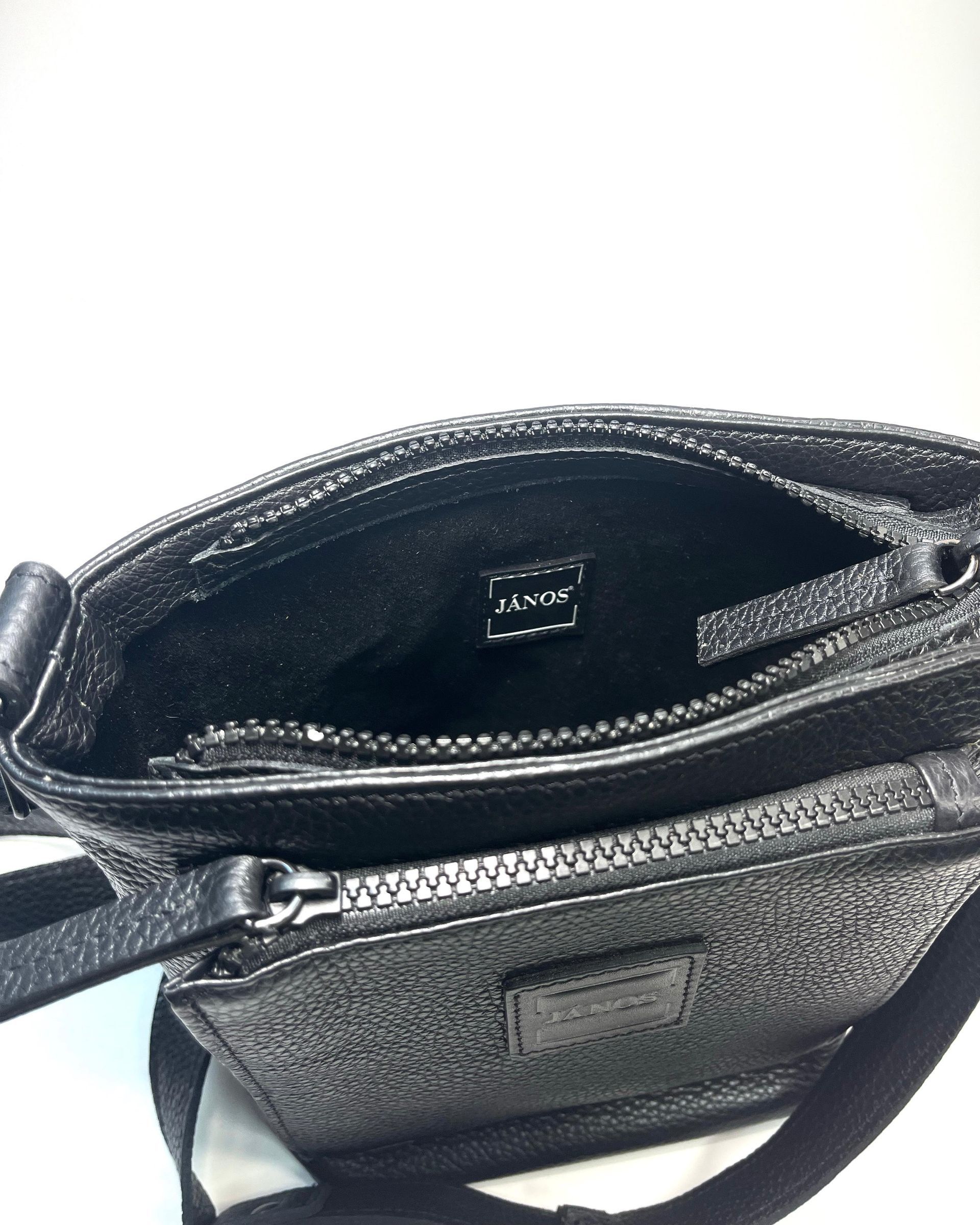 Bolso bandolera texturizado de color negro sobre fondo blanco.