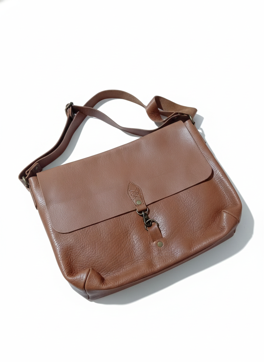 Bolso bandolera de piel marrón con solapa y bandolera.