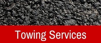 Towing Services banner. Red banner with white text overlaid on asphalt texture.