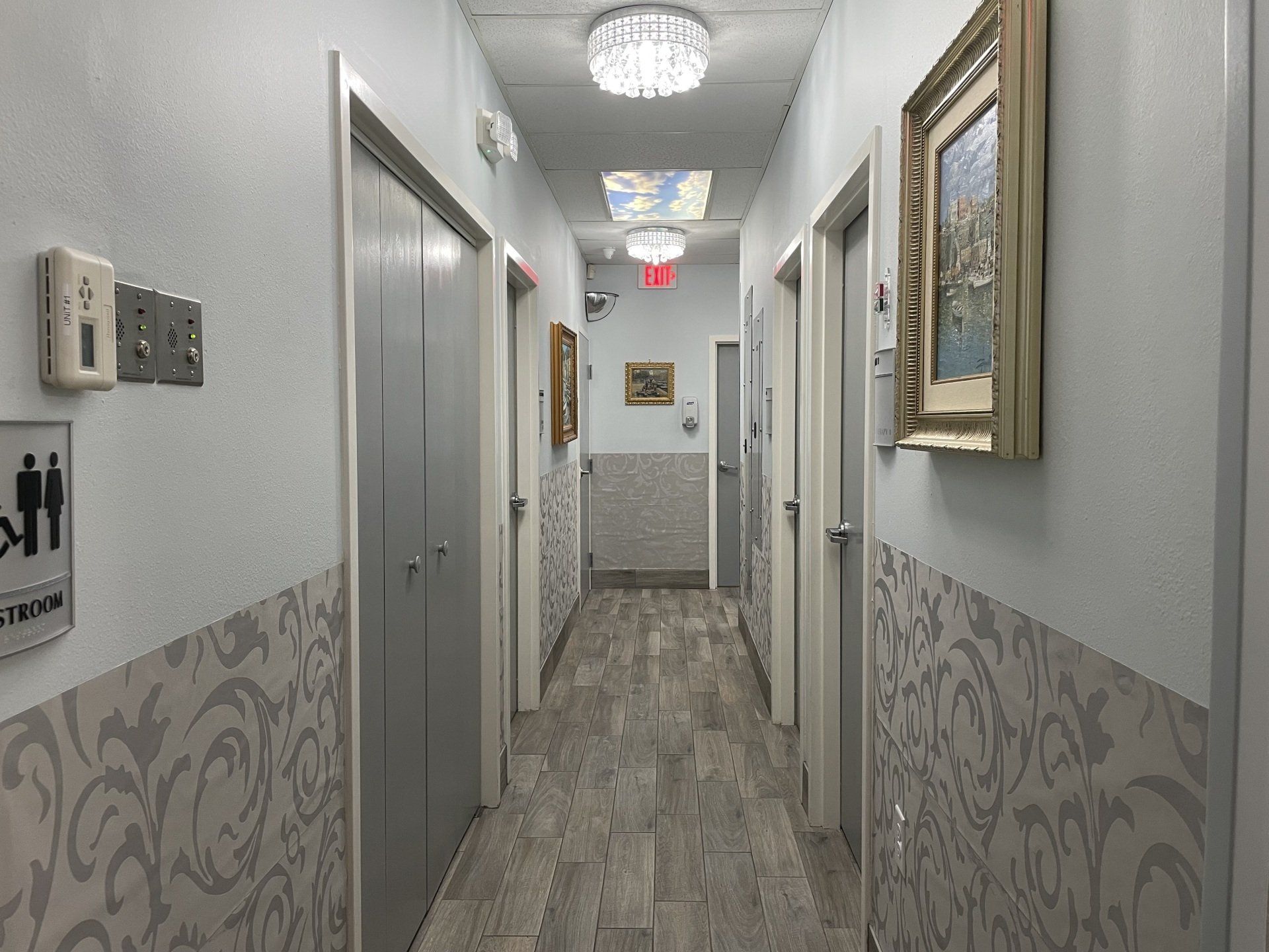 A long hallway with a toilet sign on the wall.