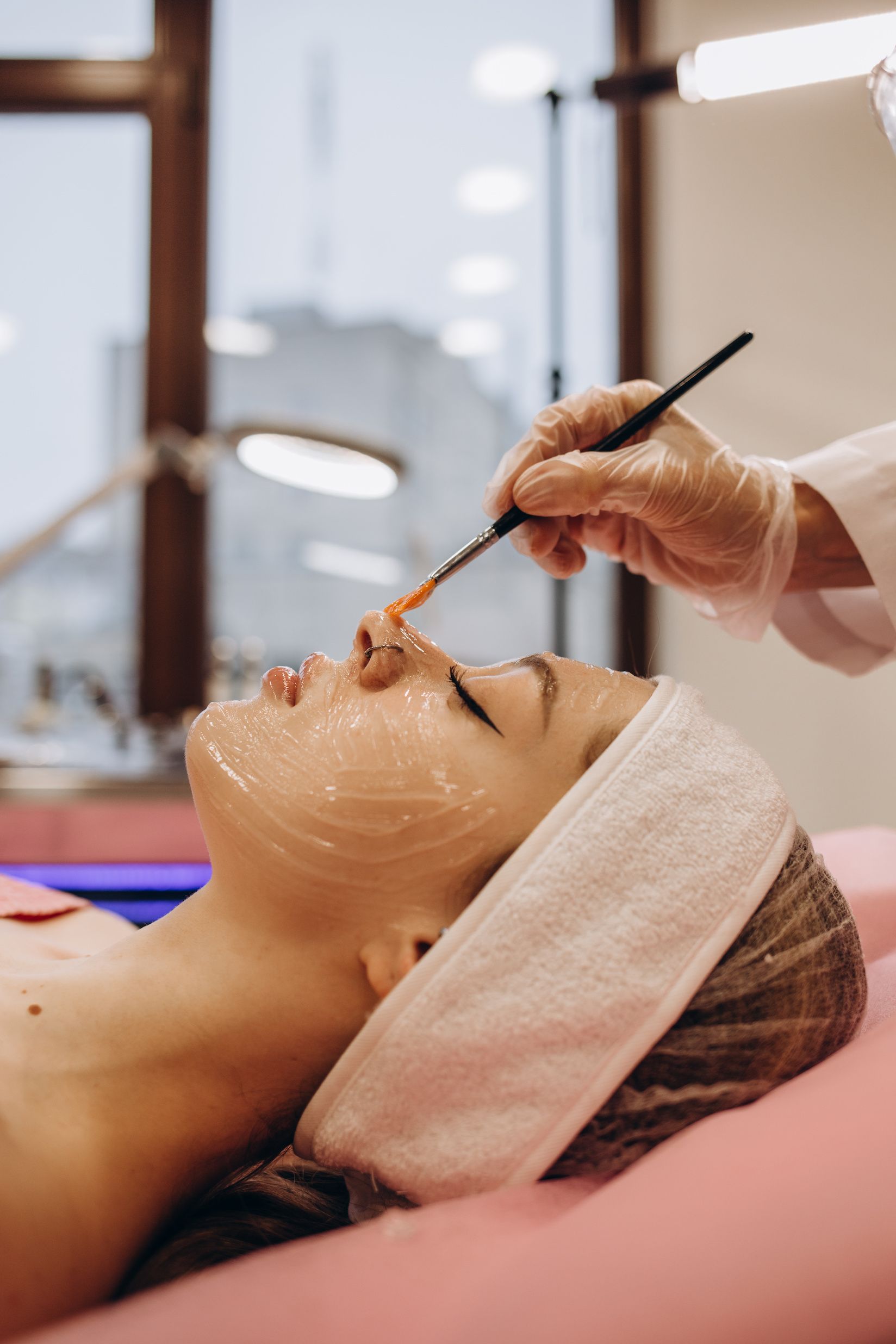 A woman is getting a facial treatment in a beauty salon.