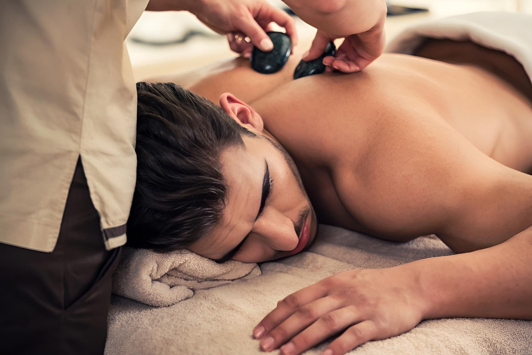 Man Receiving a Hot Stone Massage on His Back — Nonny Thai Healing Massage In Coffs Harbour, NSW