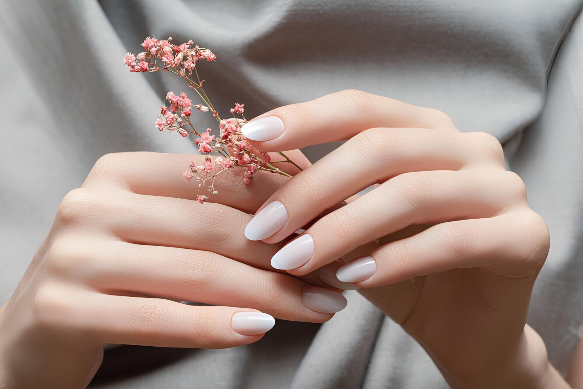 A Woman With White Nails is Holding a Flower in Her Hands — Nonny Thai Healing Massage In Coffs Harbour, NSW