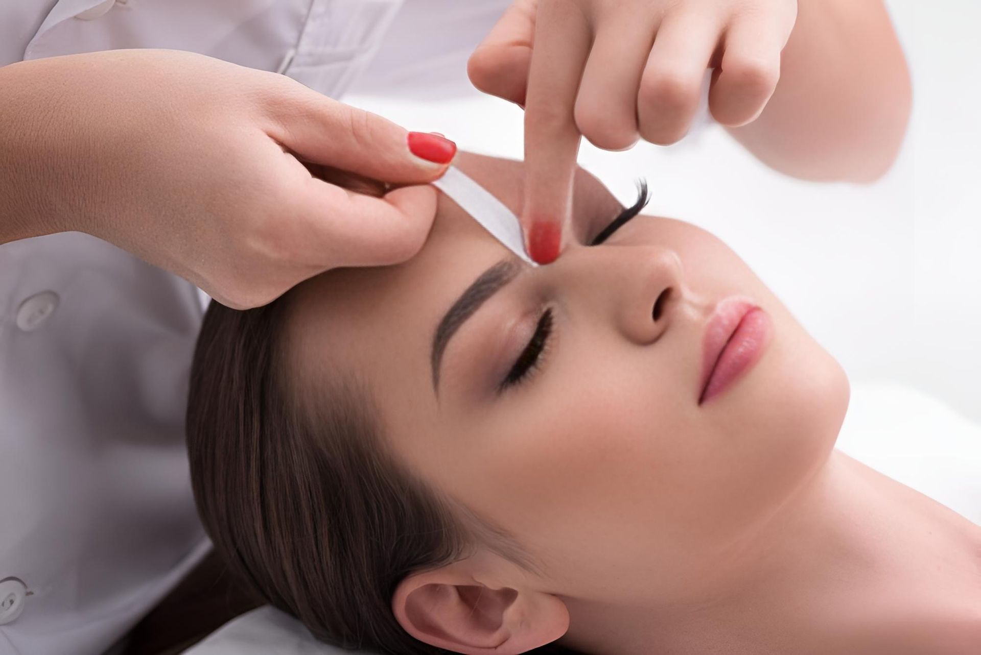 A Woman is Getting Her Eyebrows Waxed in a Beauty Salon — Nonny Thai Healing Massage In Coffs Harbour, NSW