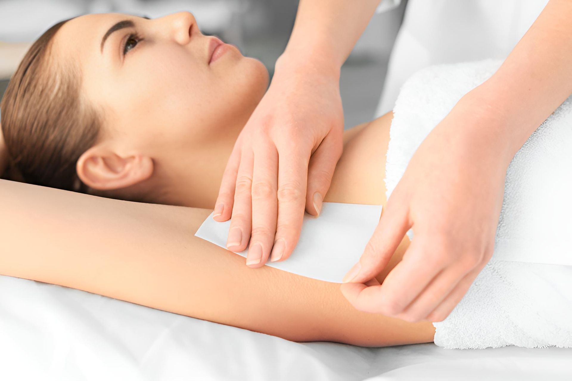 A Woman is Getting Her Armpit Waxed in a Beauty Salon — Nonny Thai Healing Massage In Coffs Harbour, NSW