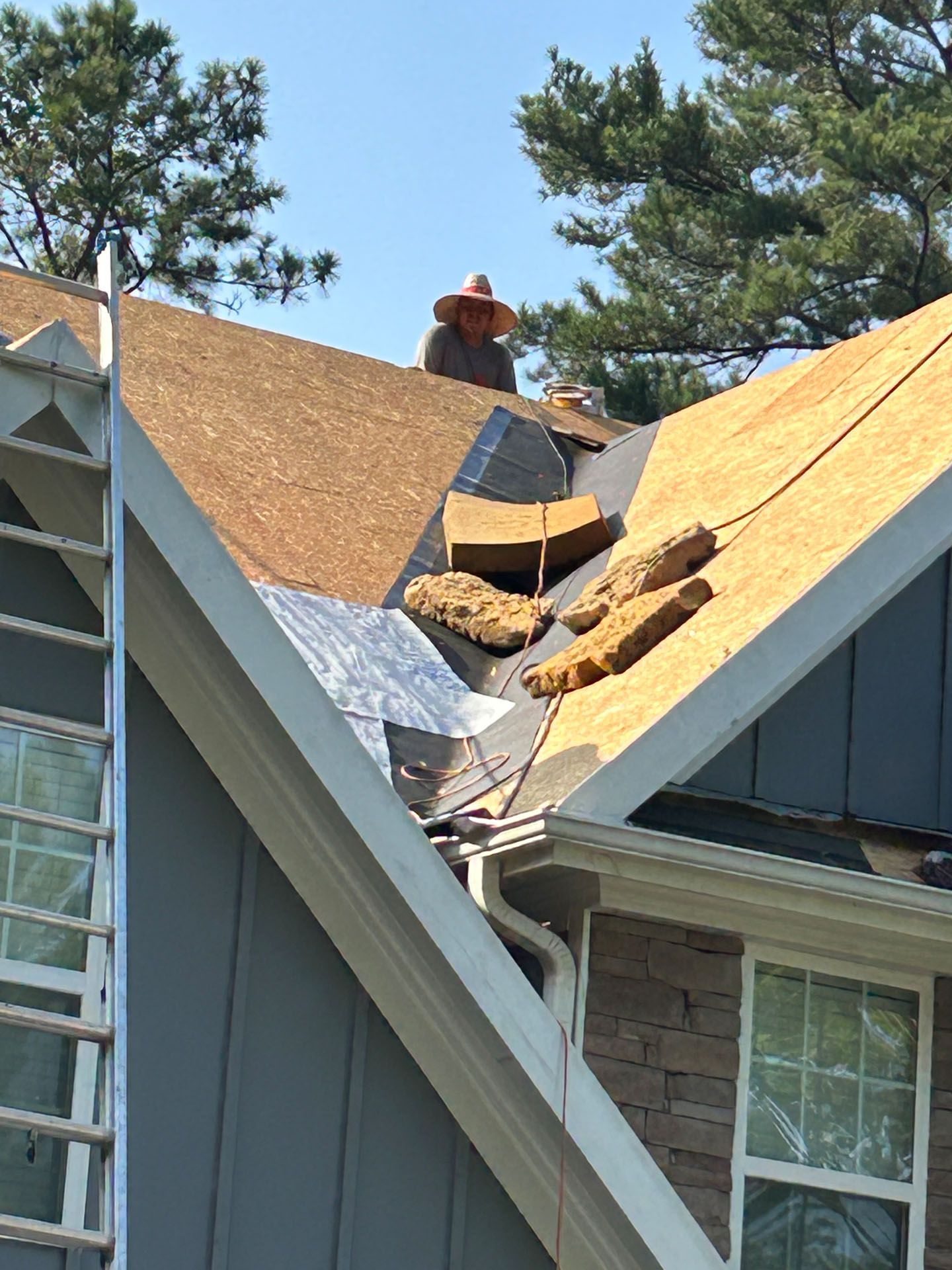 A man is working on the roof of a house.