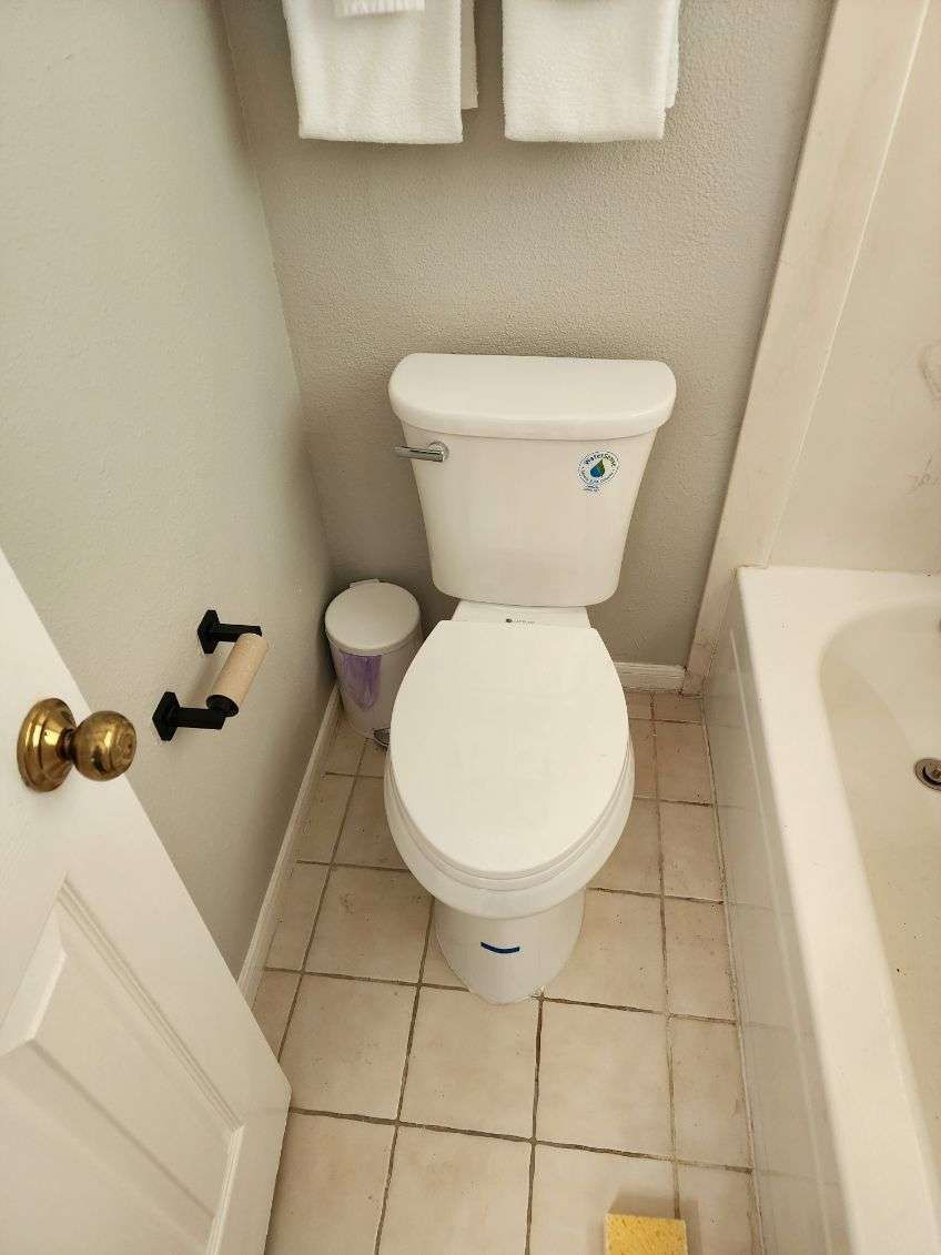 A toilet in a bathroom next to a bathtub