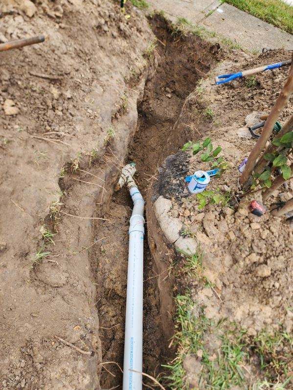 A pipe is being installed in a hole in the ground.