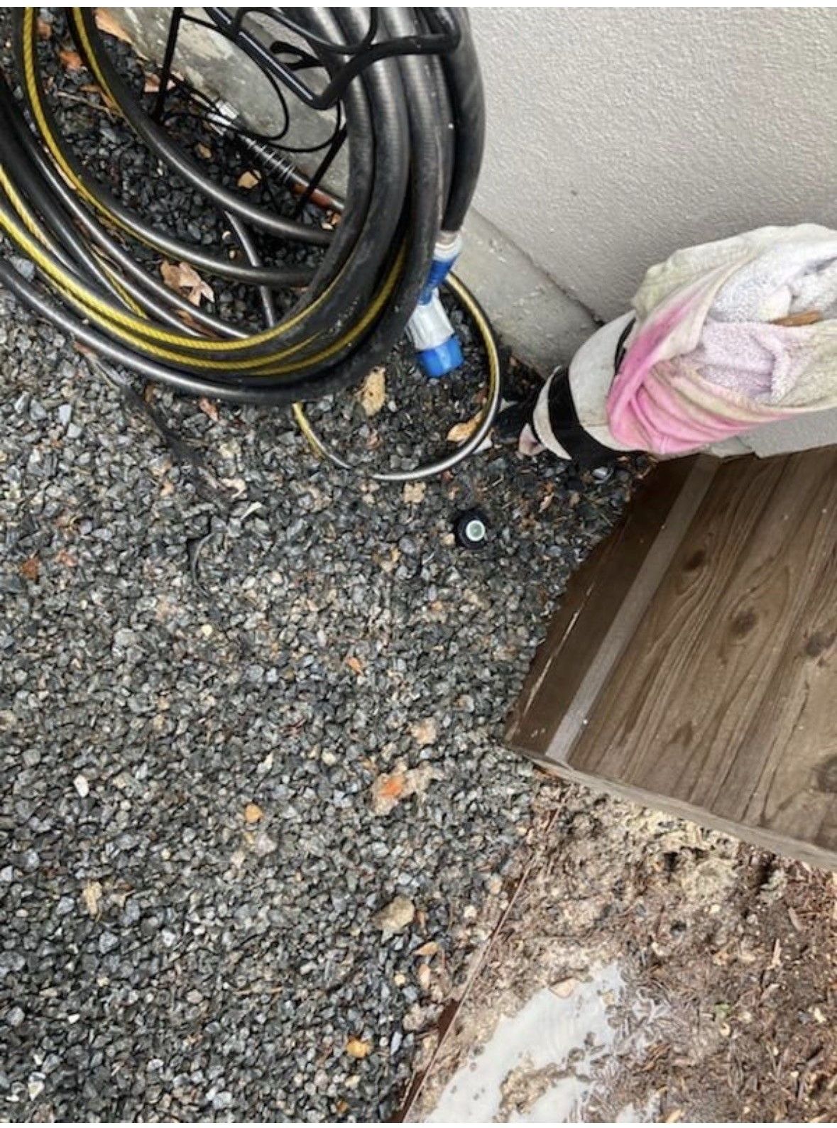A person is using a drill to drill a hole in the ground.
