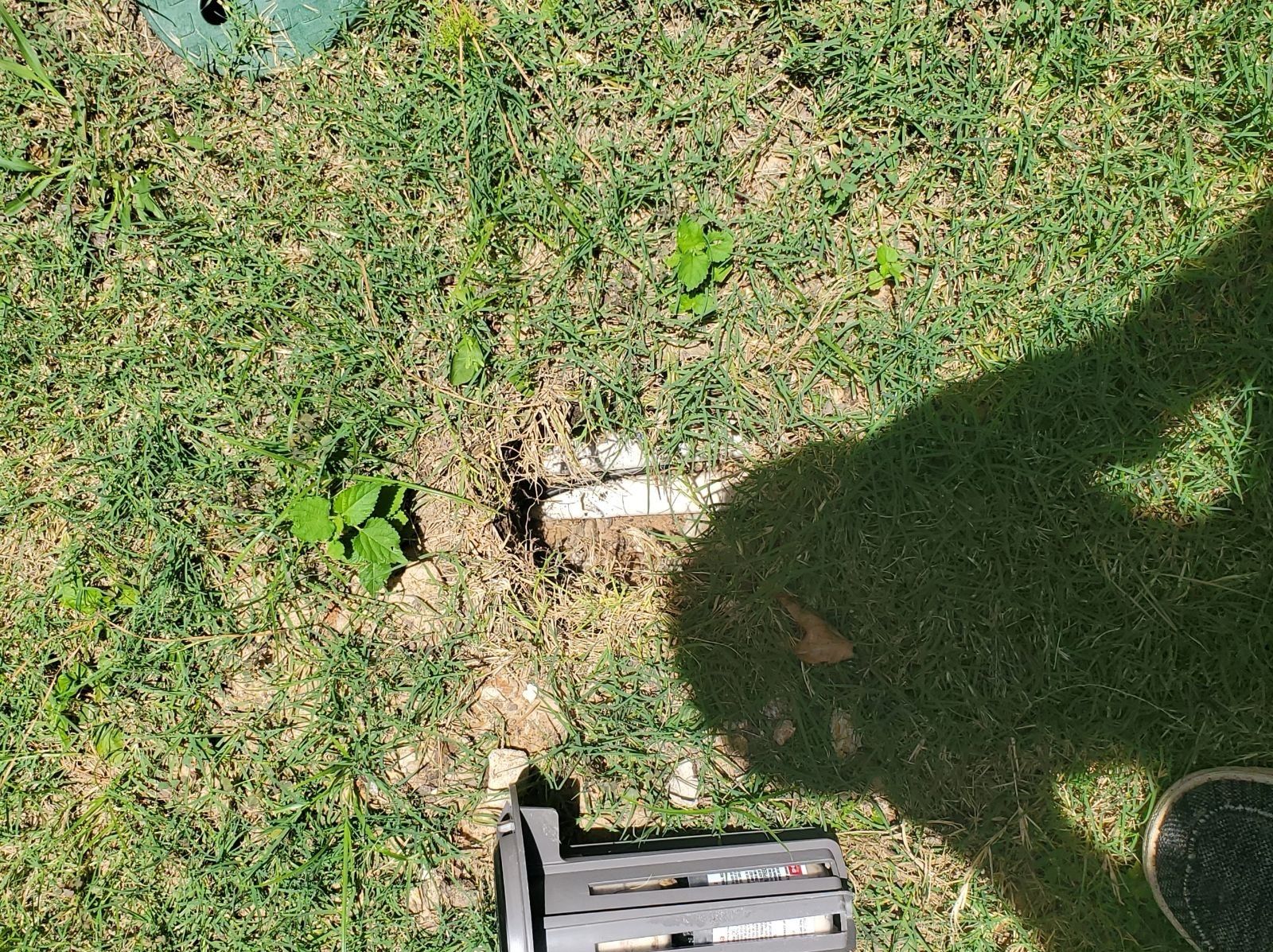 A shadow of a person is cast on the grass.