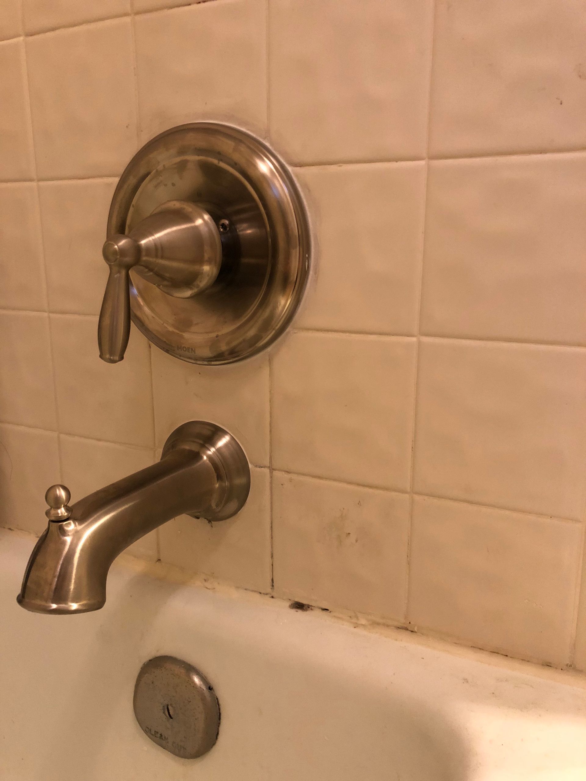 A bathtub with a faucet on the wall next to it.