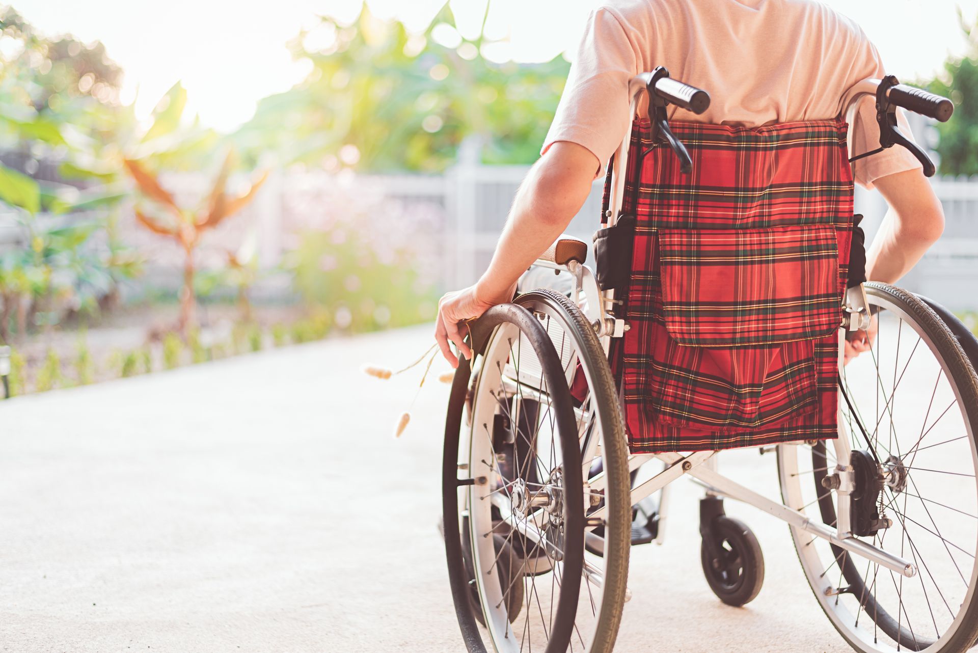 Man in wheelchair with face not visible - rear view with plaid wheelchair  backing design