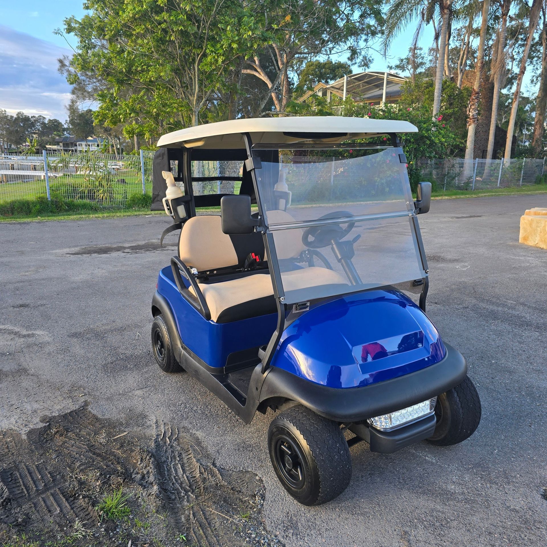 Blue Golf Cart Parked on Gravel Near Trees, With Beige Seats — Lift It Equipment in Summerland Point, NSW