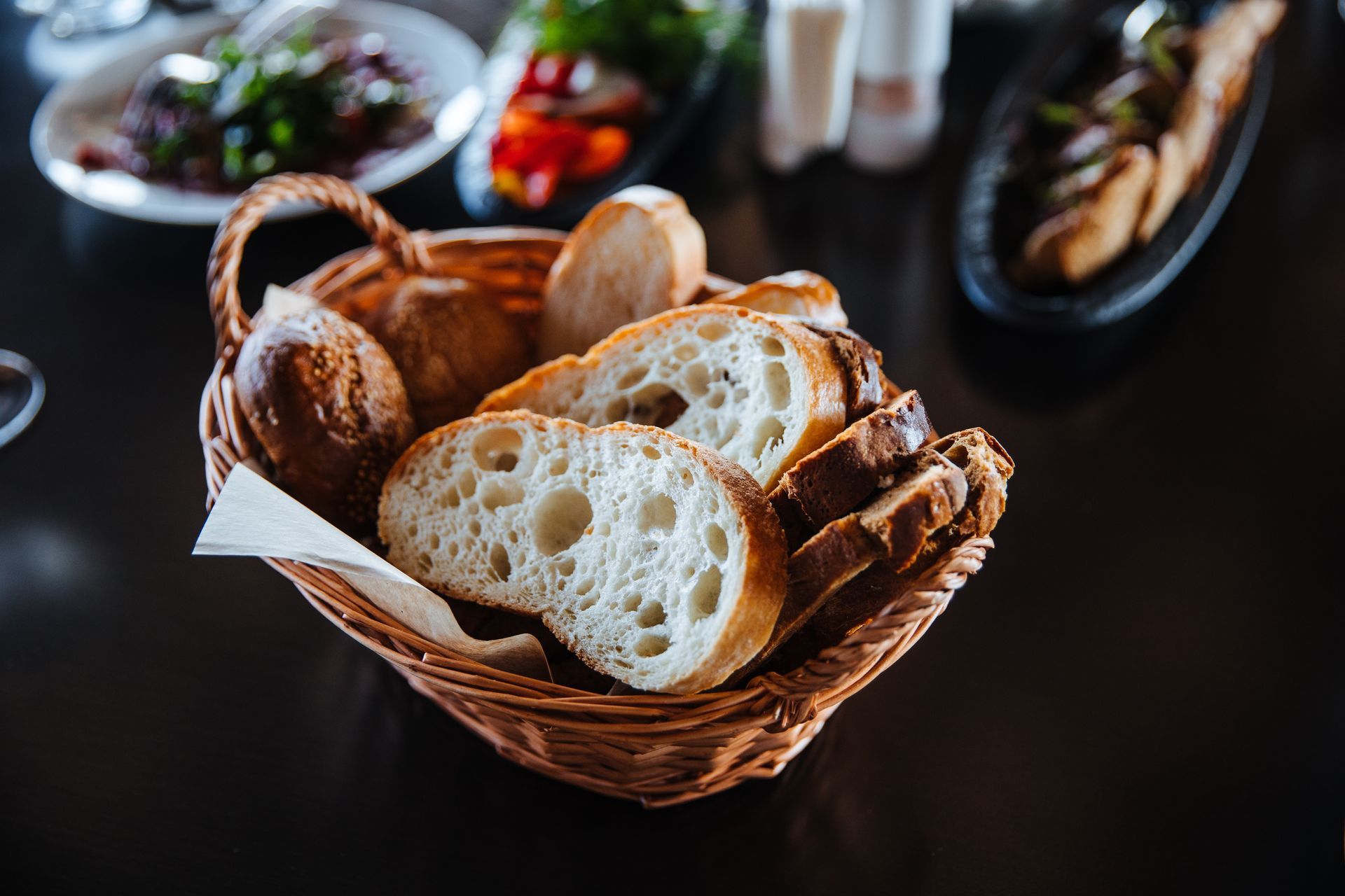 A basket of bread is sitting on a table.