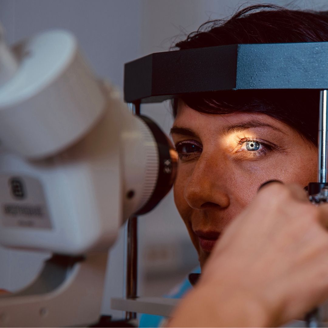 Woman having her eye examined with a slit lamp in an ophthalmologist’s office.