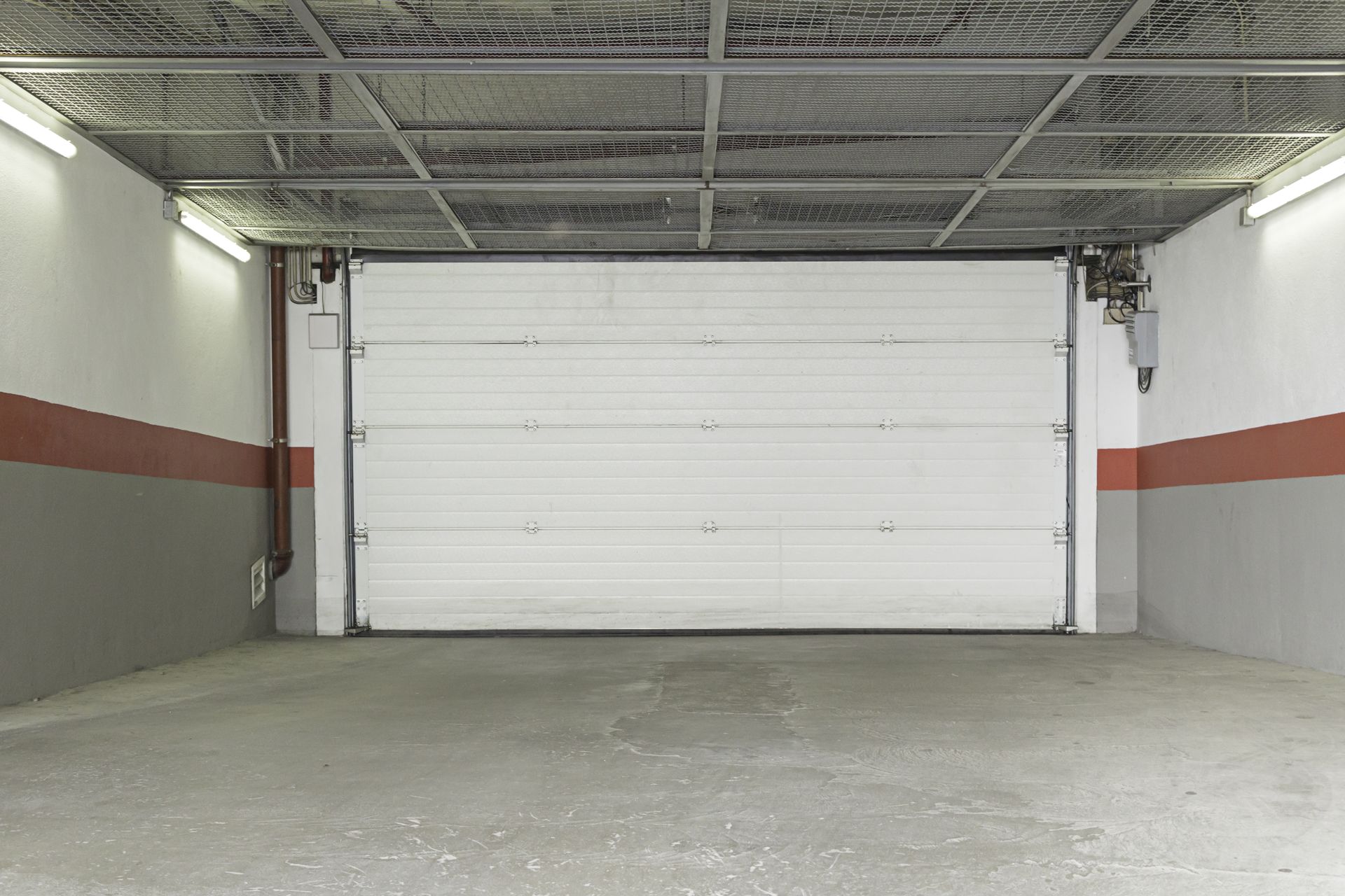 An Empty Garage With a White Garage Door Open