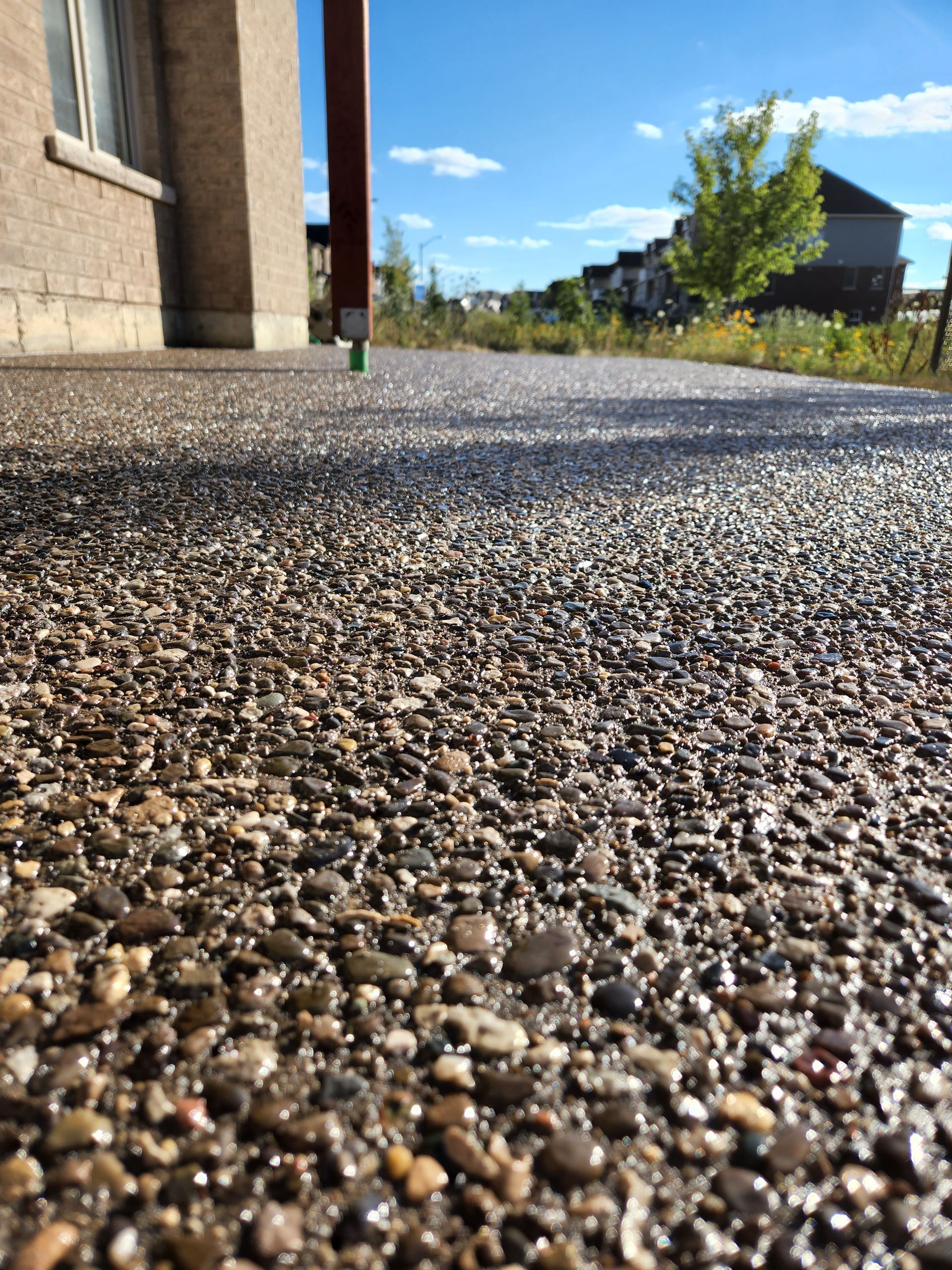 A driveway leading to a brick house with a white garage door