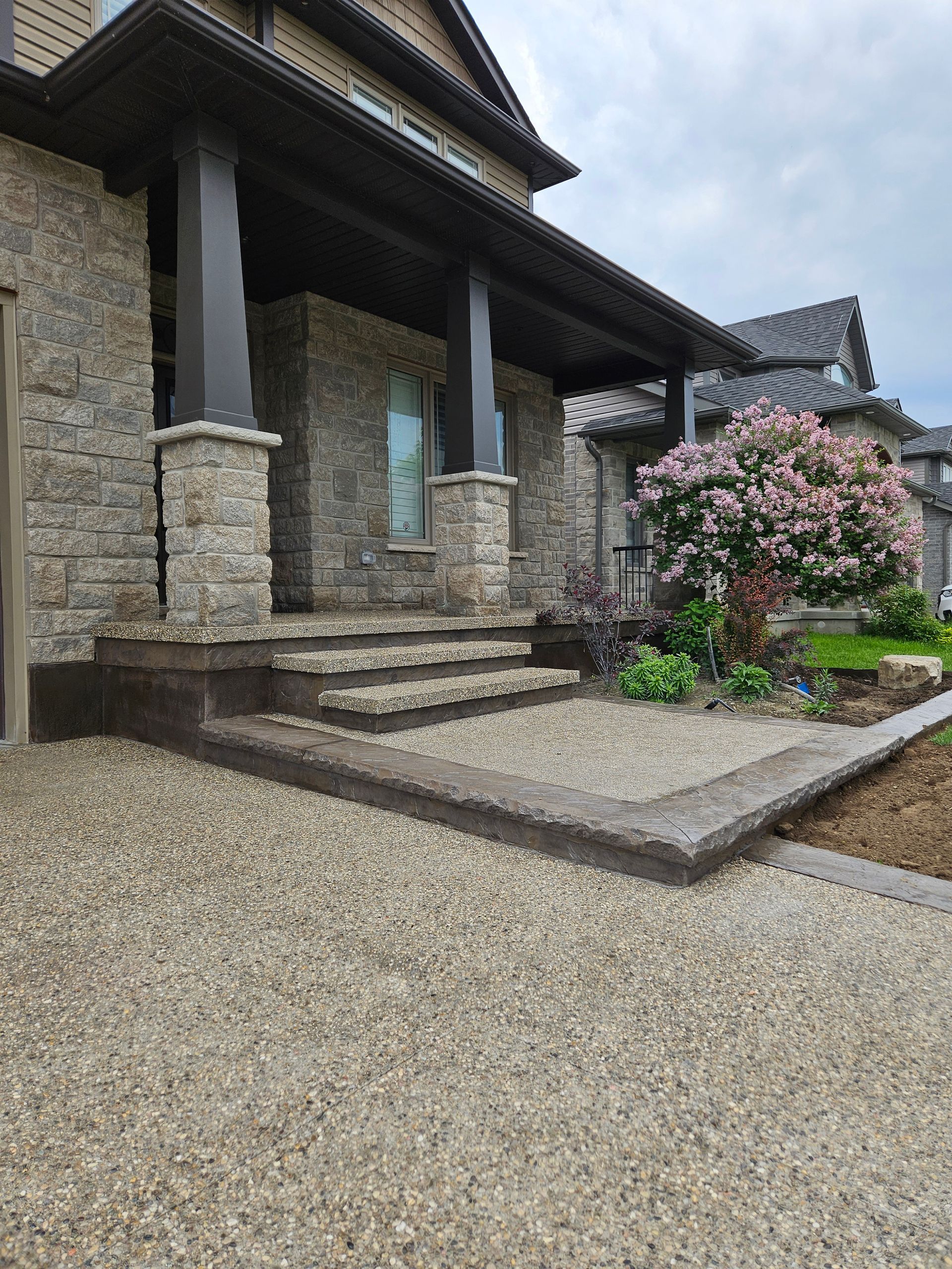 A concrete walkway with steps leading up to a brick building.