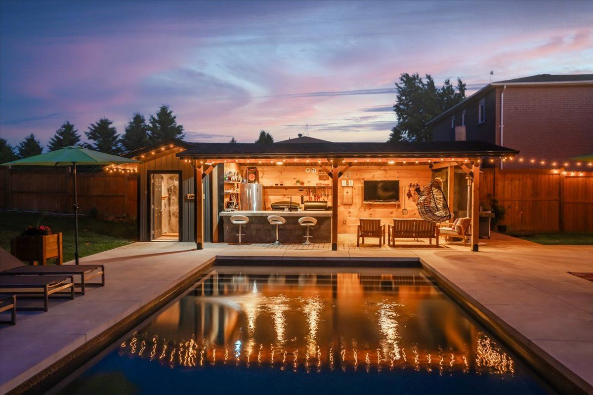 A house with a swimming pool and a kitchen in the backyard