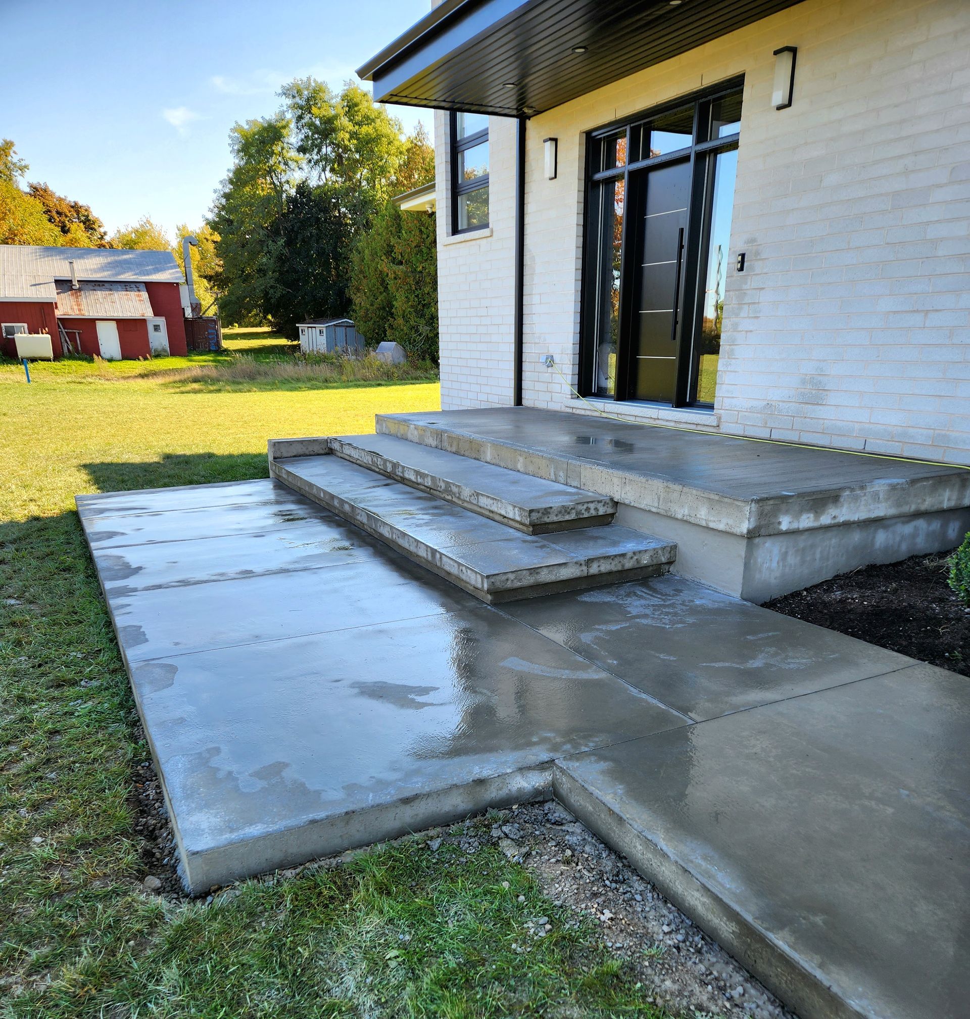 A white house with concrete steps leading up to the front door.