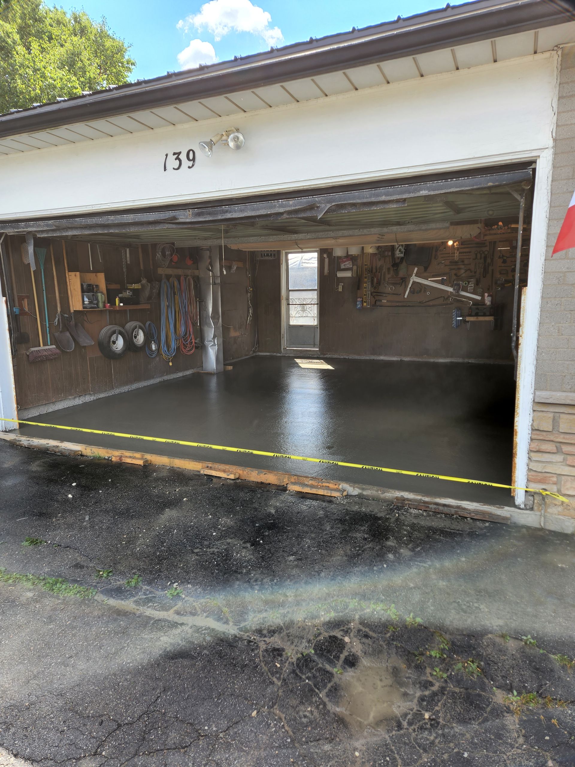 A garage with the door open and a concrete floor.