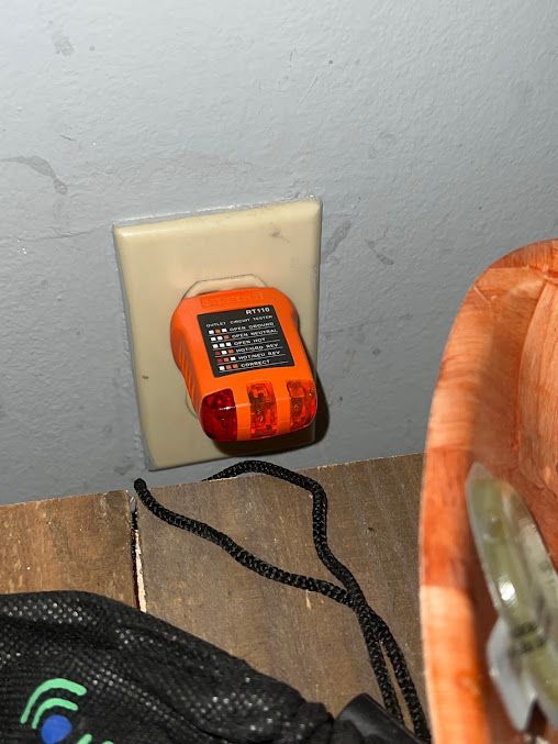 An orange device is plugged into a wall outlet