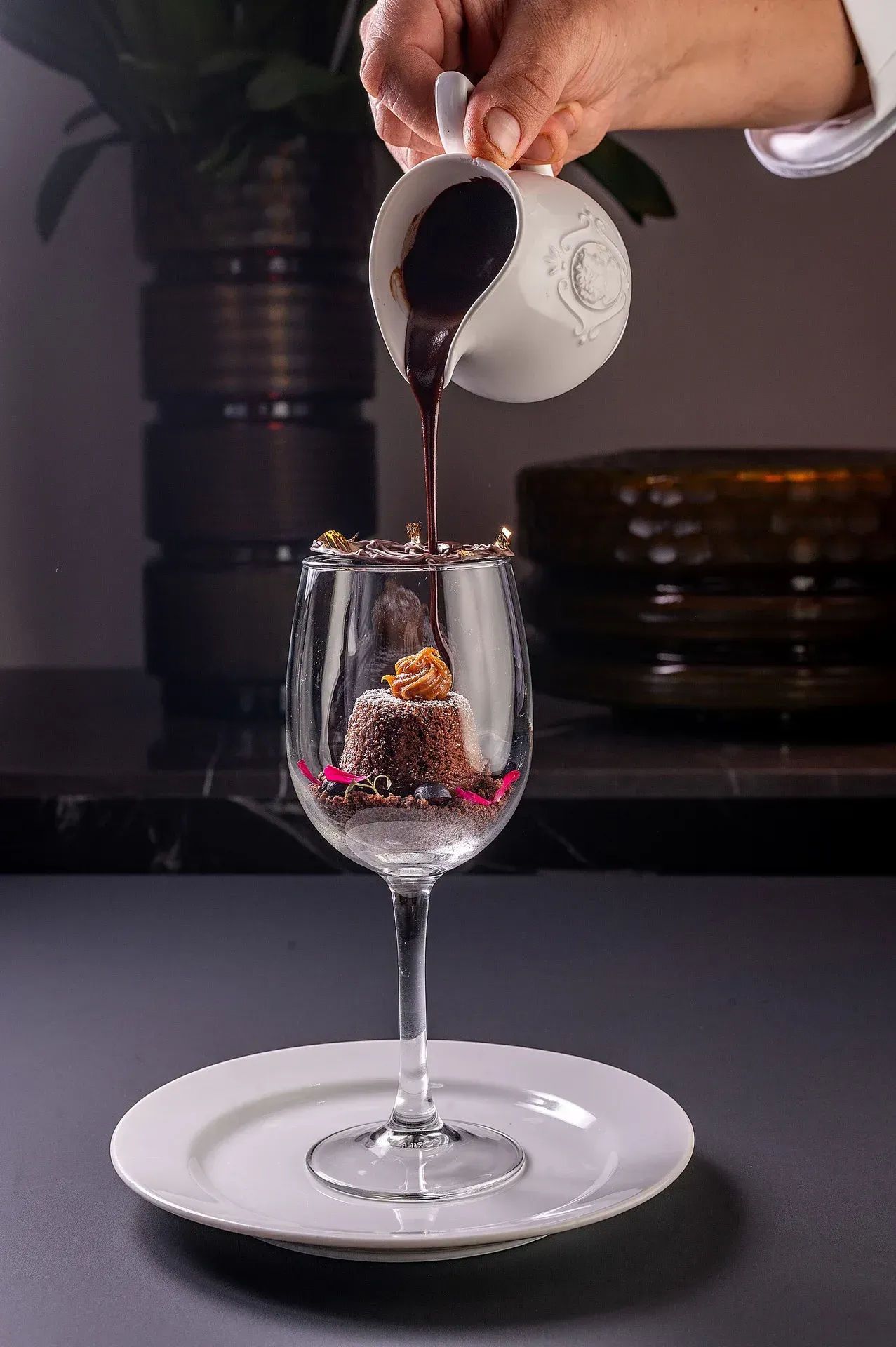 Uma pessoa está despejando chocolate em uma taça de vinho.