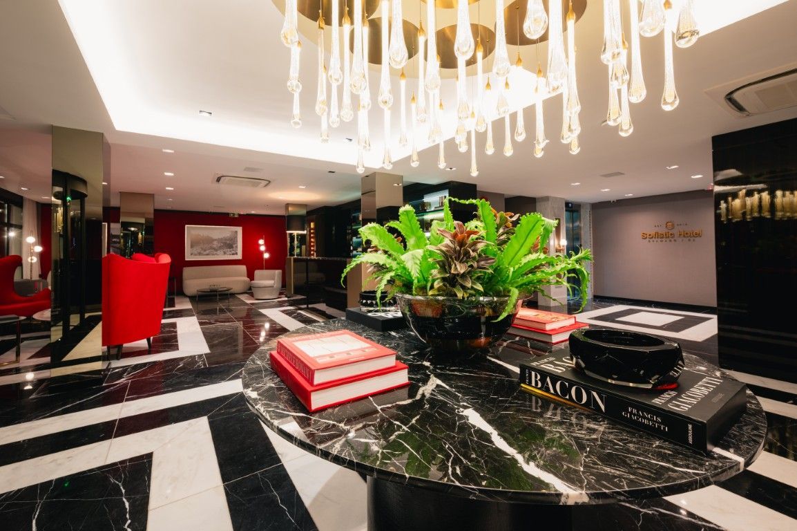 Impressão artística de um saguão de hotel com piso e cadeiras de mármore.