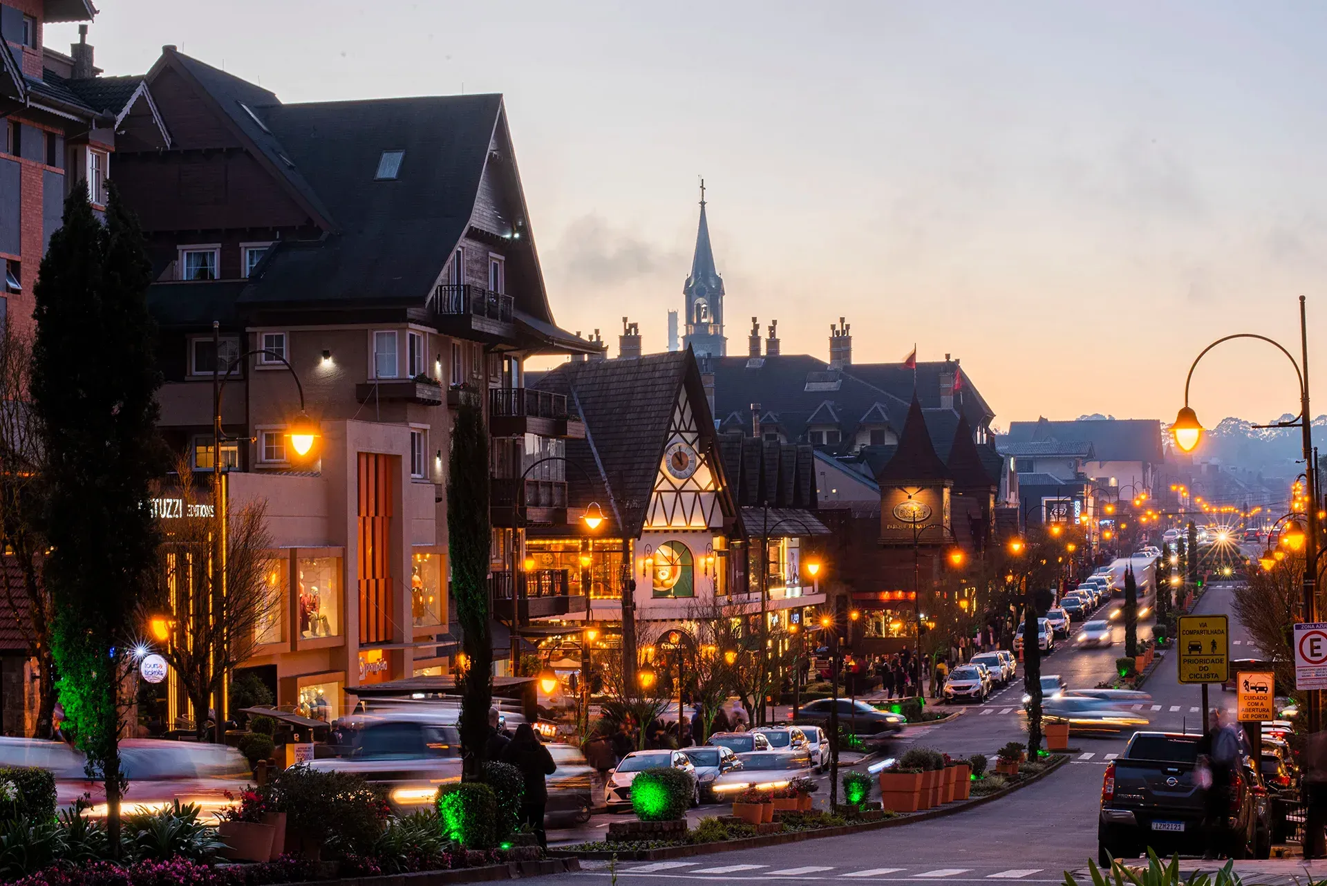 Uma rua da cidade com uma torre do relógio ao fundo