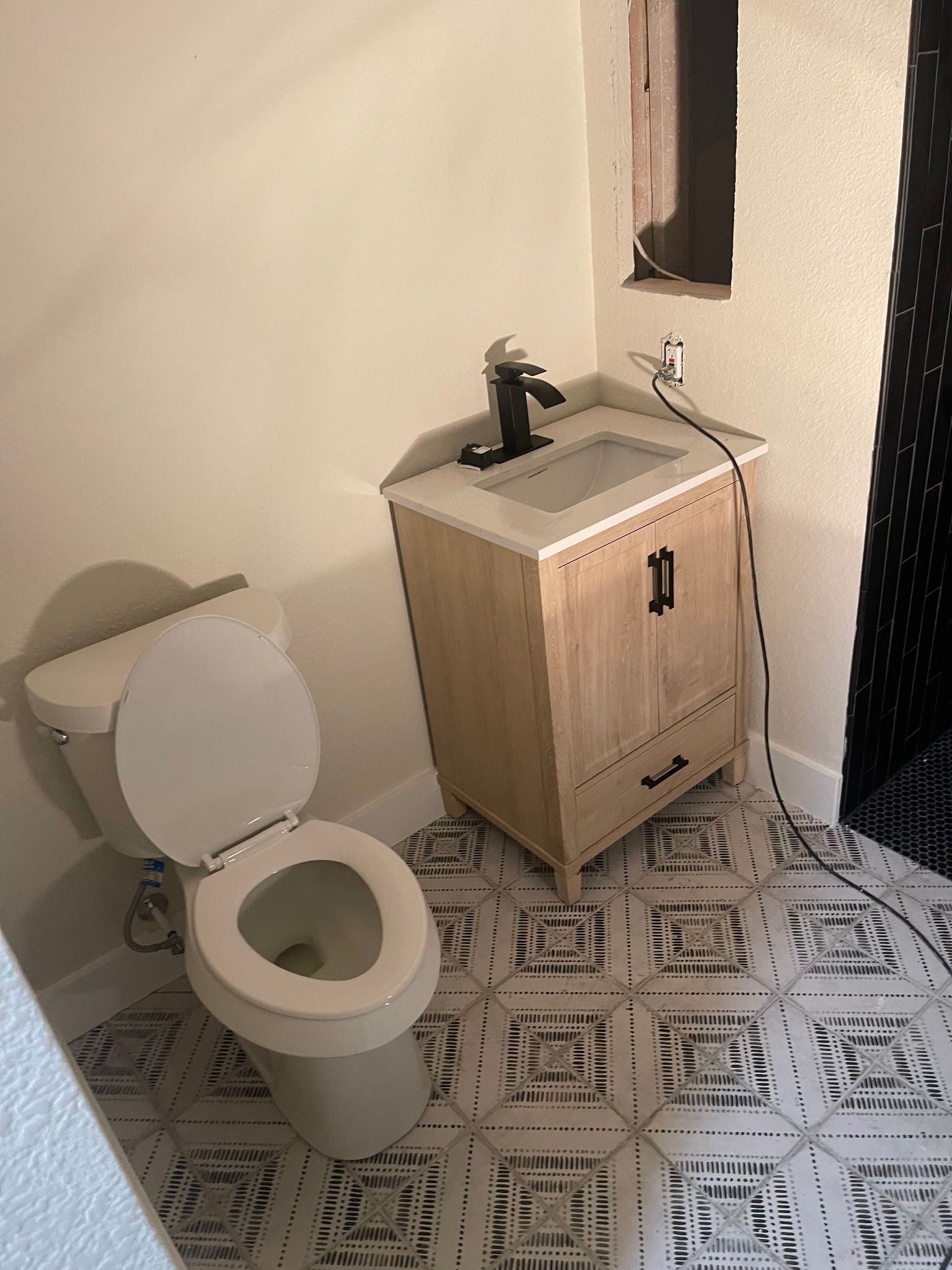Woman in straw hat smiles, holding wine glass near a lake.