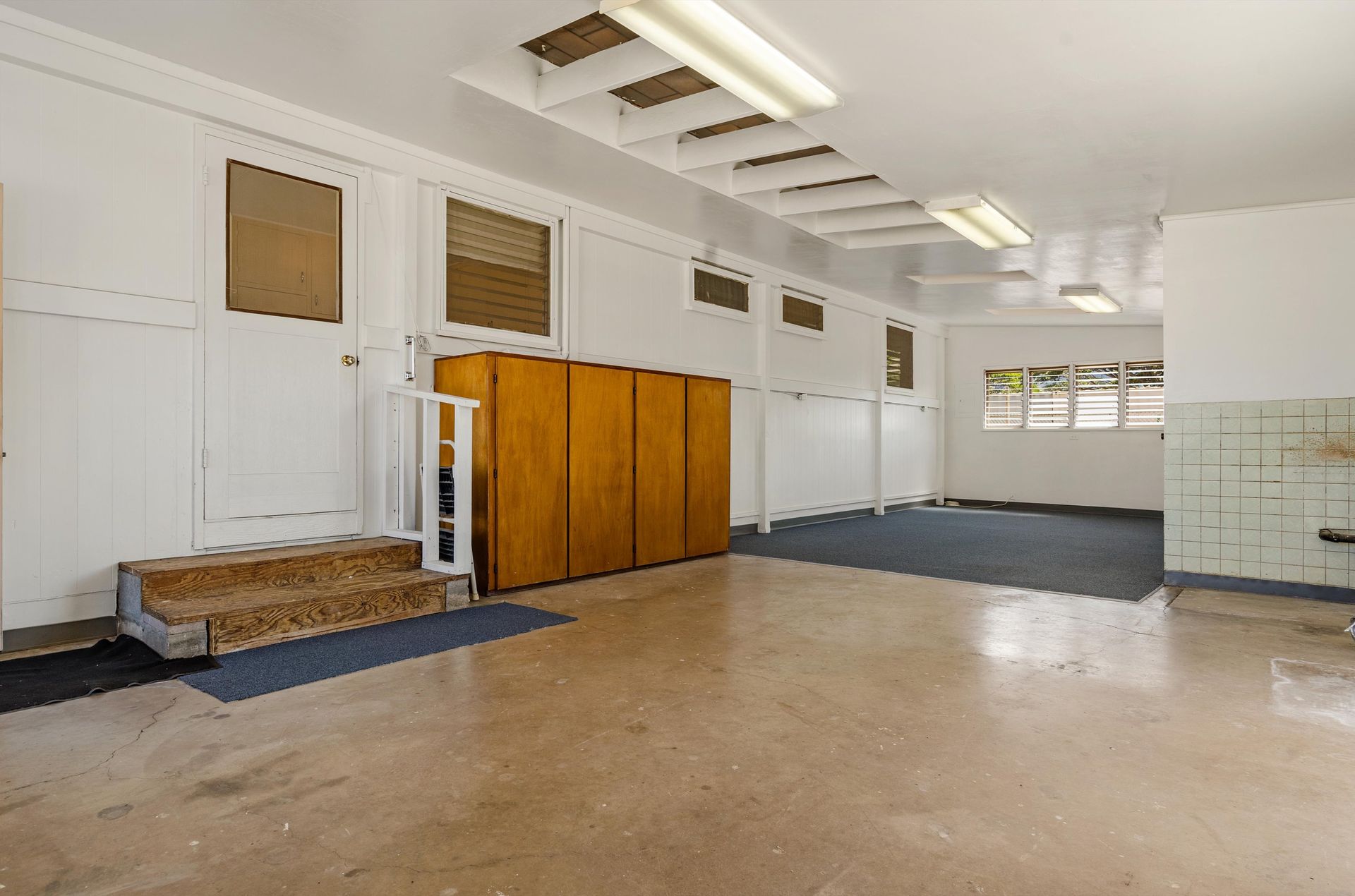 A large empty room with a staircase leading up to it.