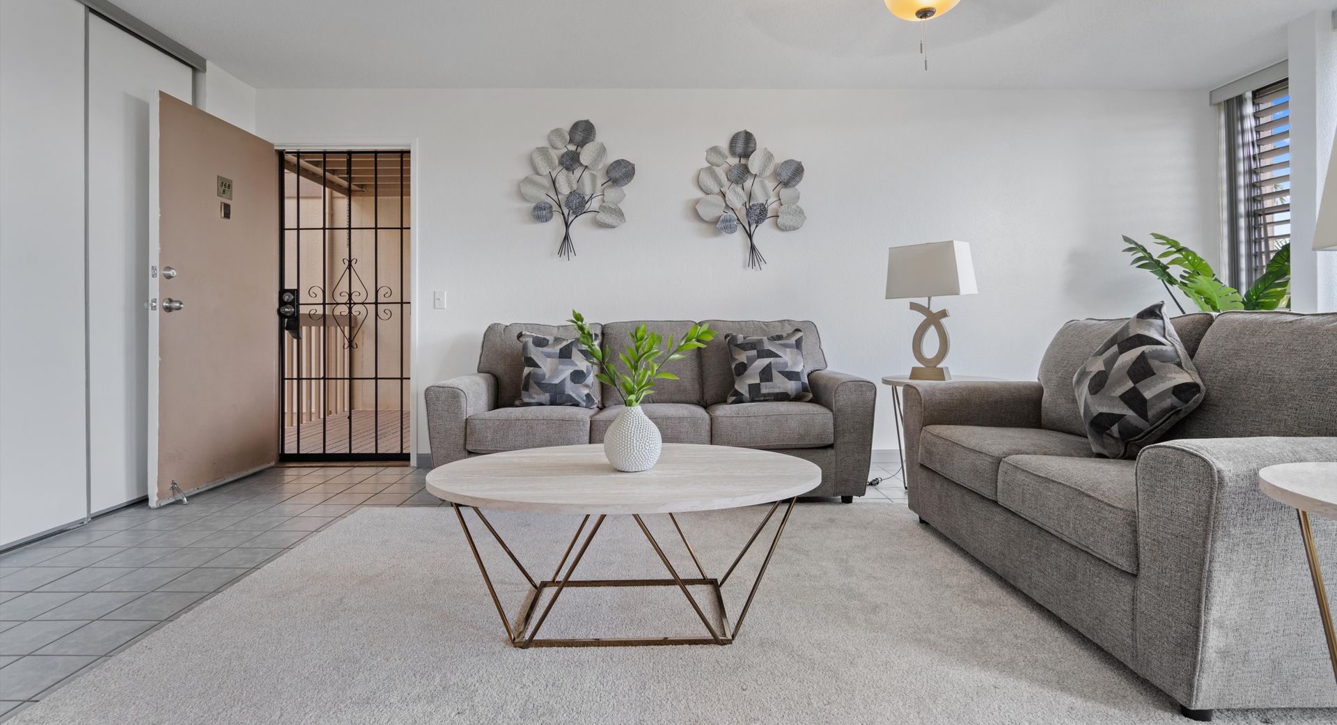 A living room with two couches , a coffee table , and a rug.