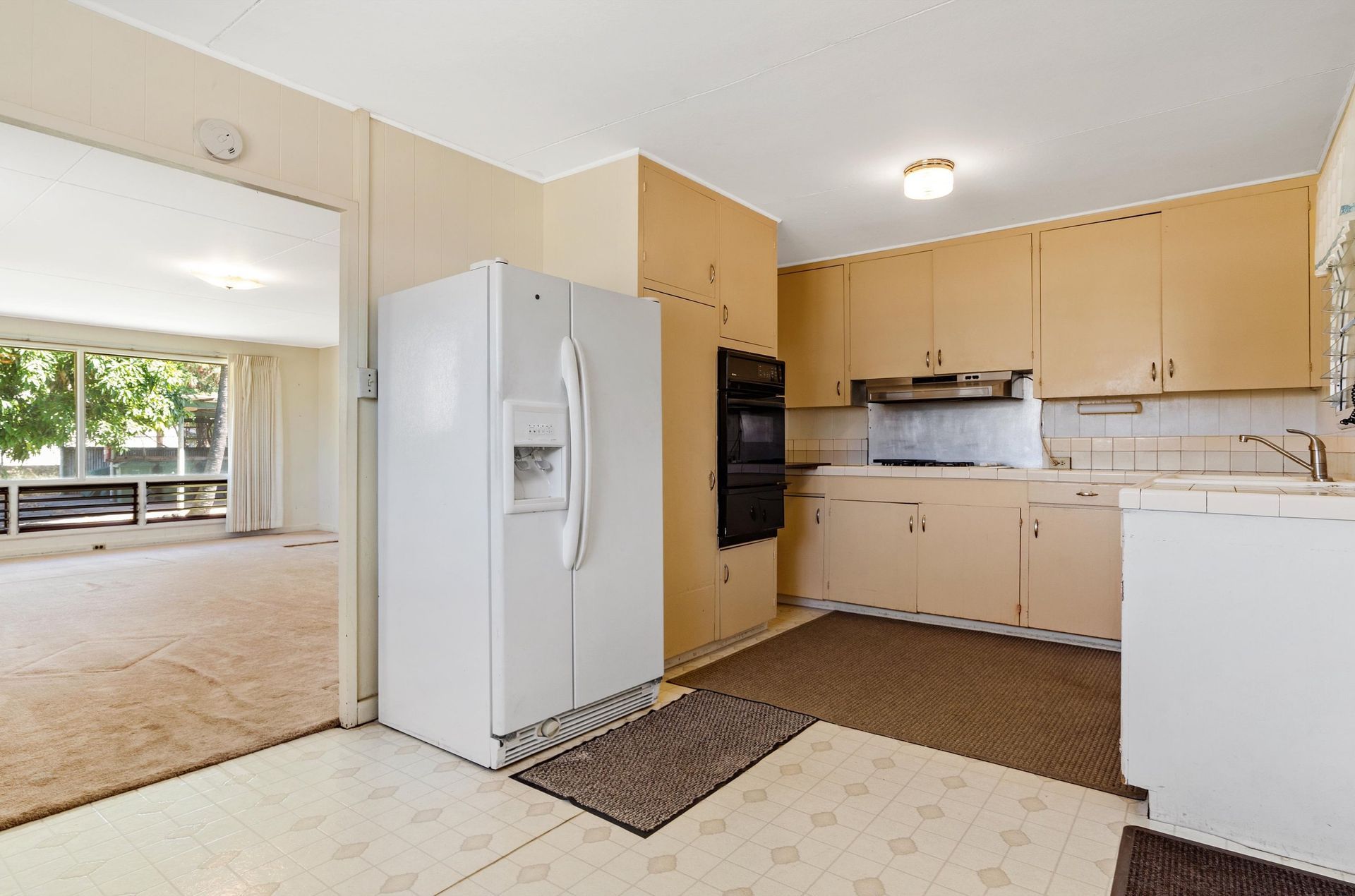 A kitchen with beige cabinets and a white refrigerator.