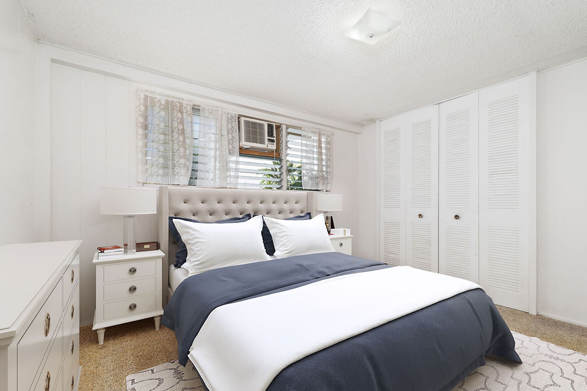 A bedroom with a bed , dresser , nightstand , and window.